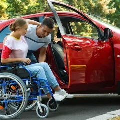 A female being assisted into her modified car - Driving Lessons For People With Physical Impairments and Disabilities on The Gold Coast